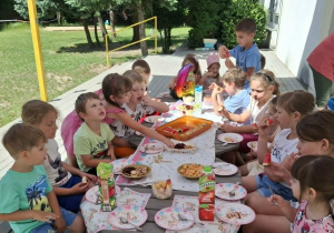 grupa dzieci na tarsie, w trakcie poczęstunku urodzinowego