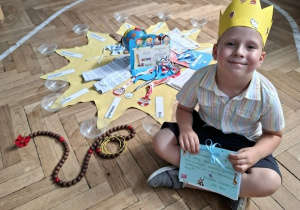 chłopiec siedzi przed urodzinowym słoneczkiem