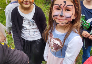 Zdjęcie przedstawia dwie dziewczynki z pomalowanymi twarzami.