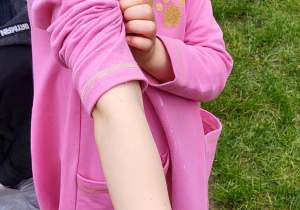 Zdjęcie przedstawia dziewczynkę, która pokazuje tatuaż zrobiony na swojej rączce.
