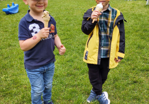 Zdjęcie przedstawia dwóch chłopców jedzących lody.