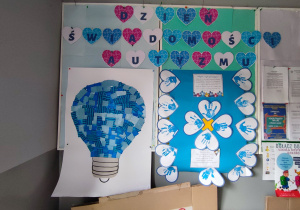 Zdjęcie przestawia tablicę, na której znajduje się napis Dzień Świadomości Autyzmu oraz dwa niebieskie plakaty.