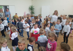 Zdjęcie przedstawia dzieci i nauczycieli biorących udział w zabawie muzyczno- ruchowej.